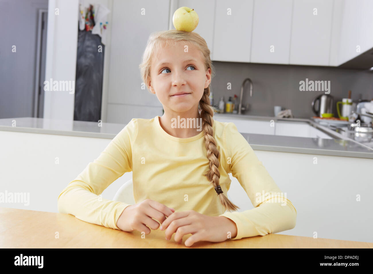 Ragazza con apple bilanciato sulla sua testa Foto Stock