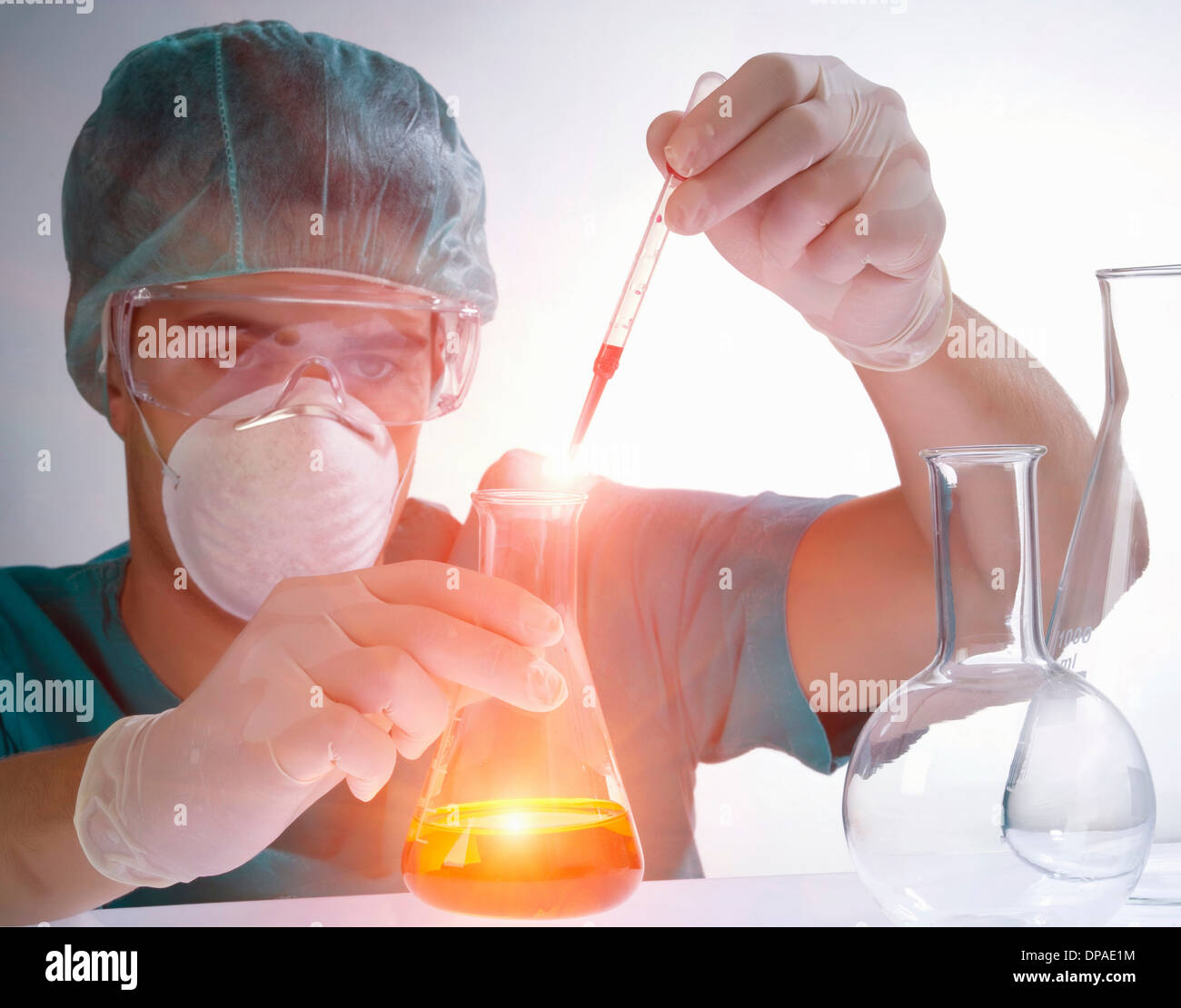 Scienziato versando il liquido da una pipetta Foto Stock