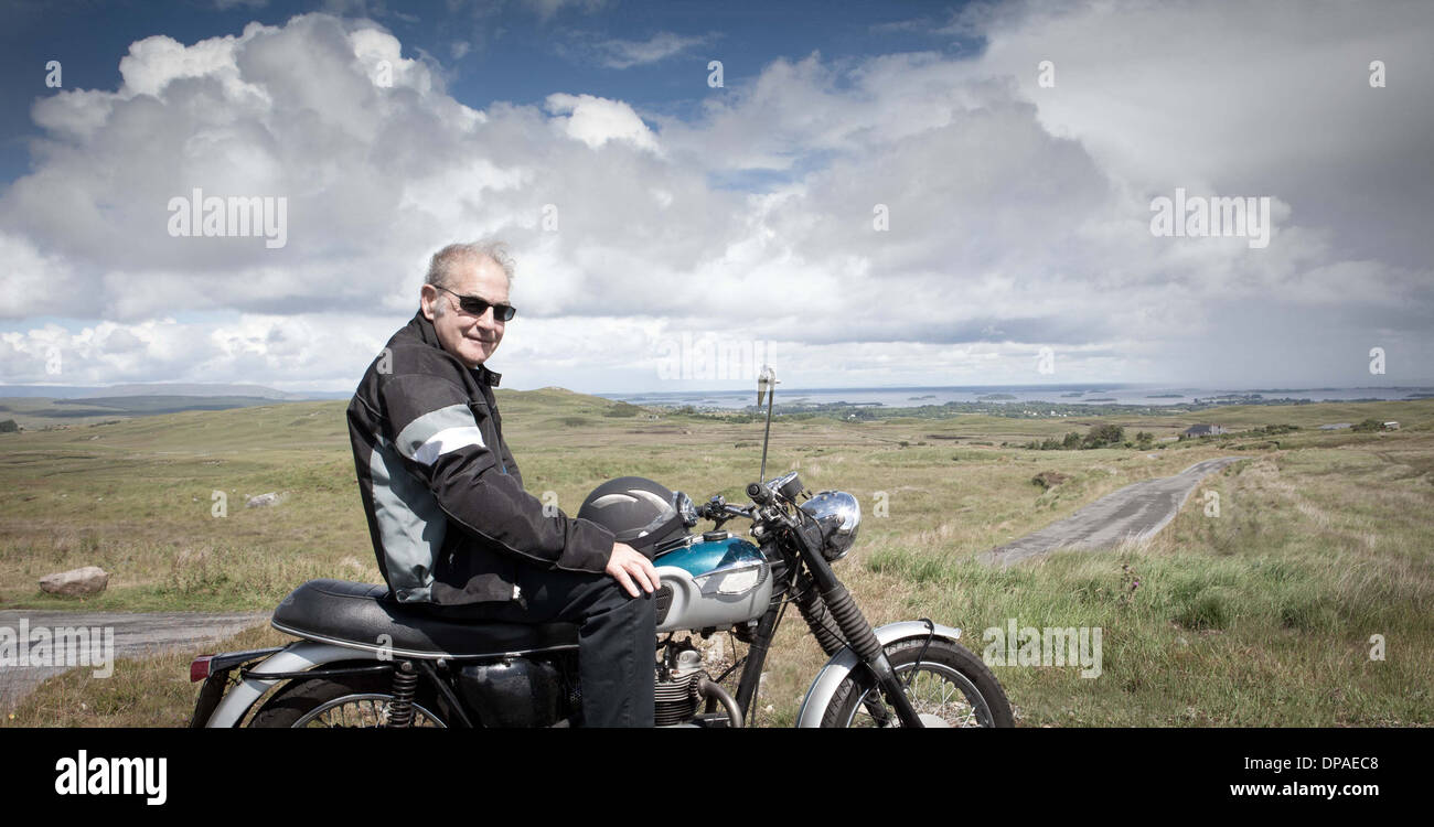 Maschio Senior motociclista prendendo una pausa Foto Stock