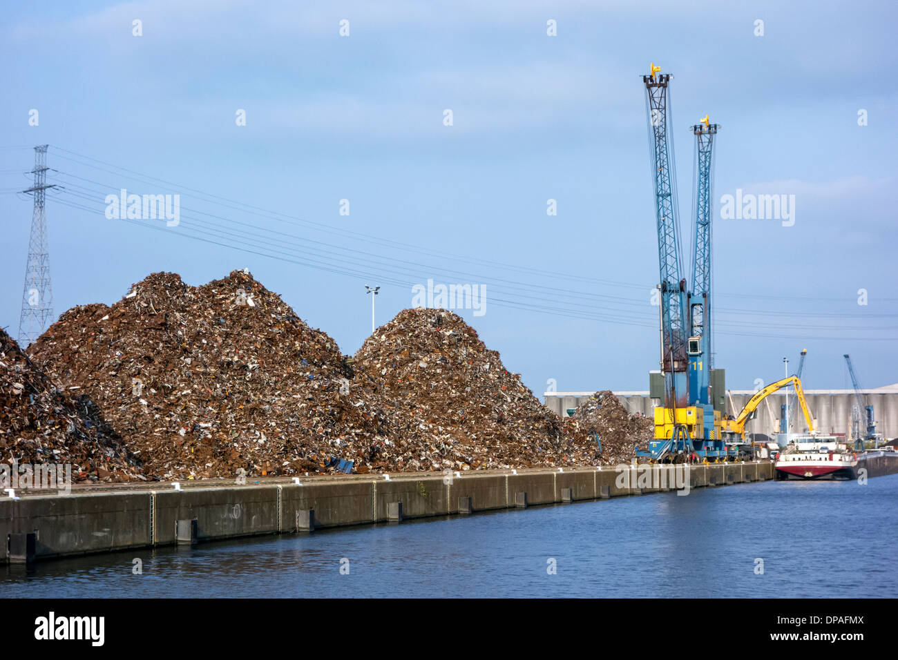 Gru di banchina e cumuli di rottami riciclati metallo a Van Heyghen riciclaggio terminale di esportazione, porto di Gand, Fiandre Orientali, Belgio Foto Stock