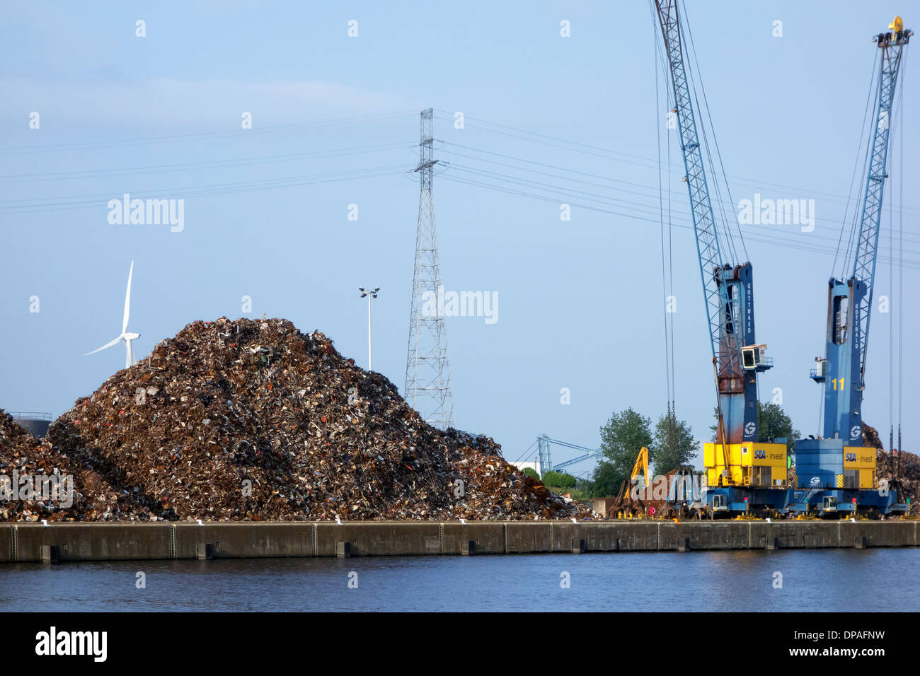 Gru di banchina e cumuli di rottami riciclati metallo a Van Heyghen riciclaggio terminale di esportazione, porto di Gand, Fiandre Orientali, Belgio Foto Stock