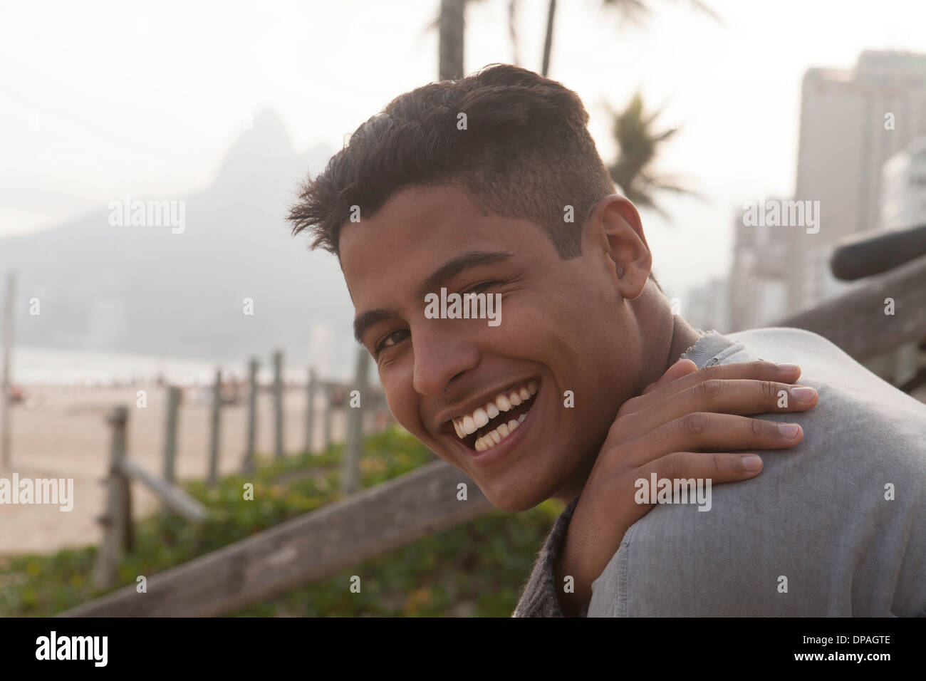 Ritratto di giovane uomo con corti capelli neri, sorridente Foto Stock
