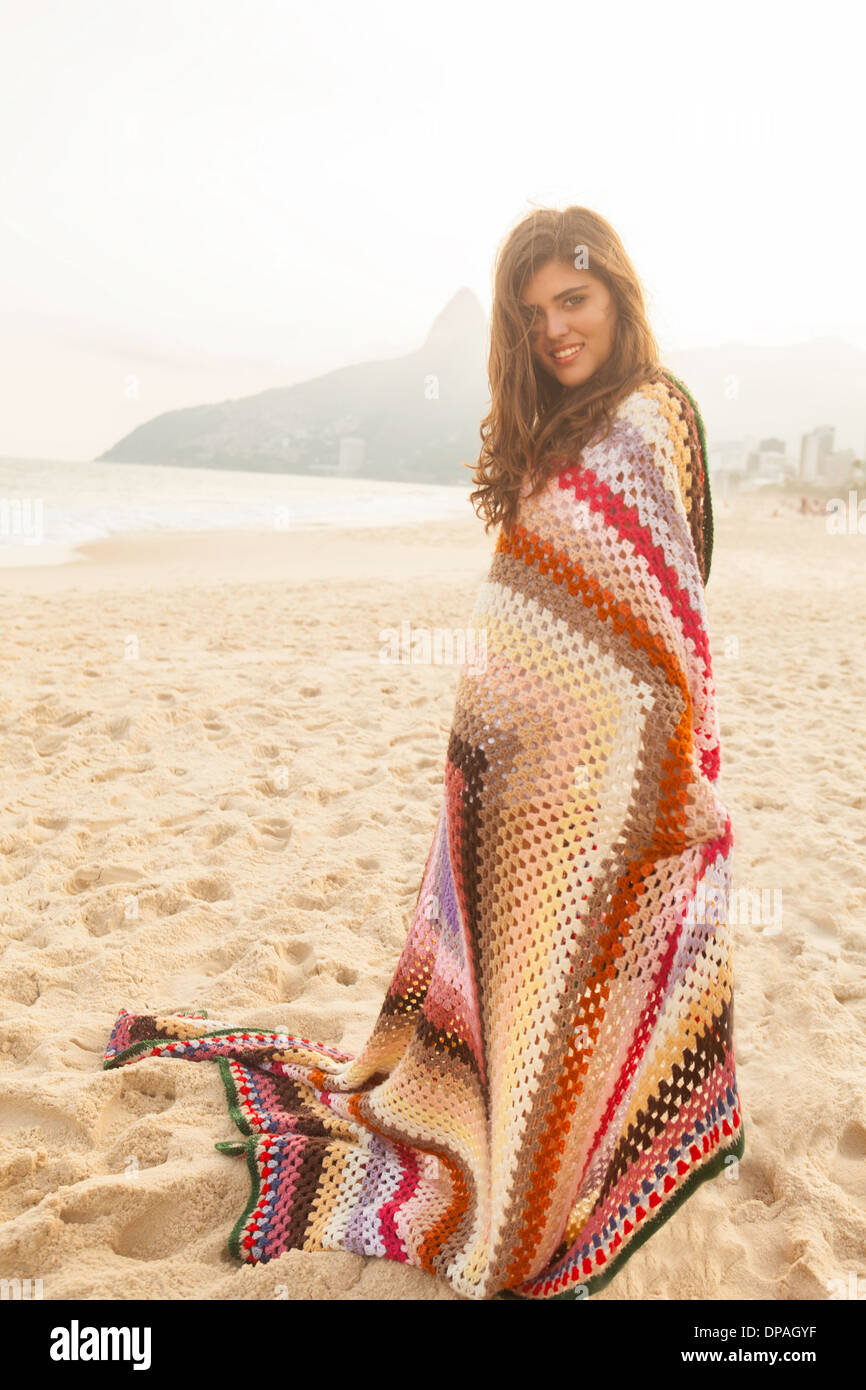Giovane donna avvolta in una coperta, la spiaggia di Ipanema, Rio de Janeiro, Brasile Foto Stock