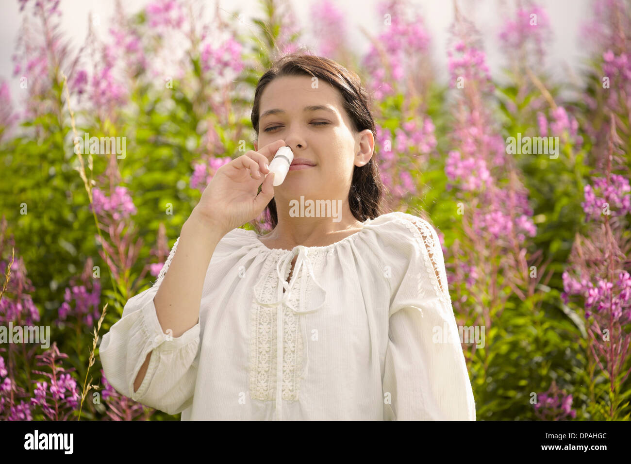 Donna che utilizza protezione antiallergie spray nasale Foto Stock