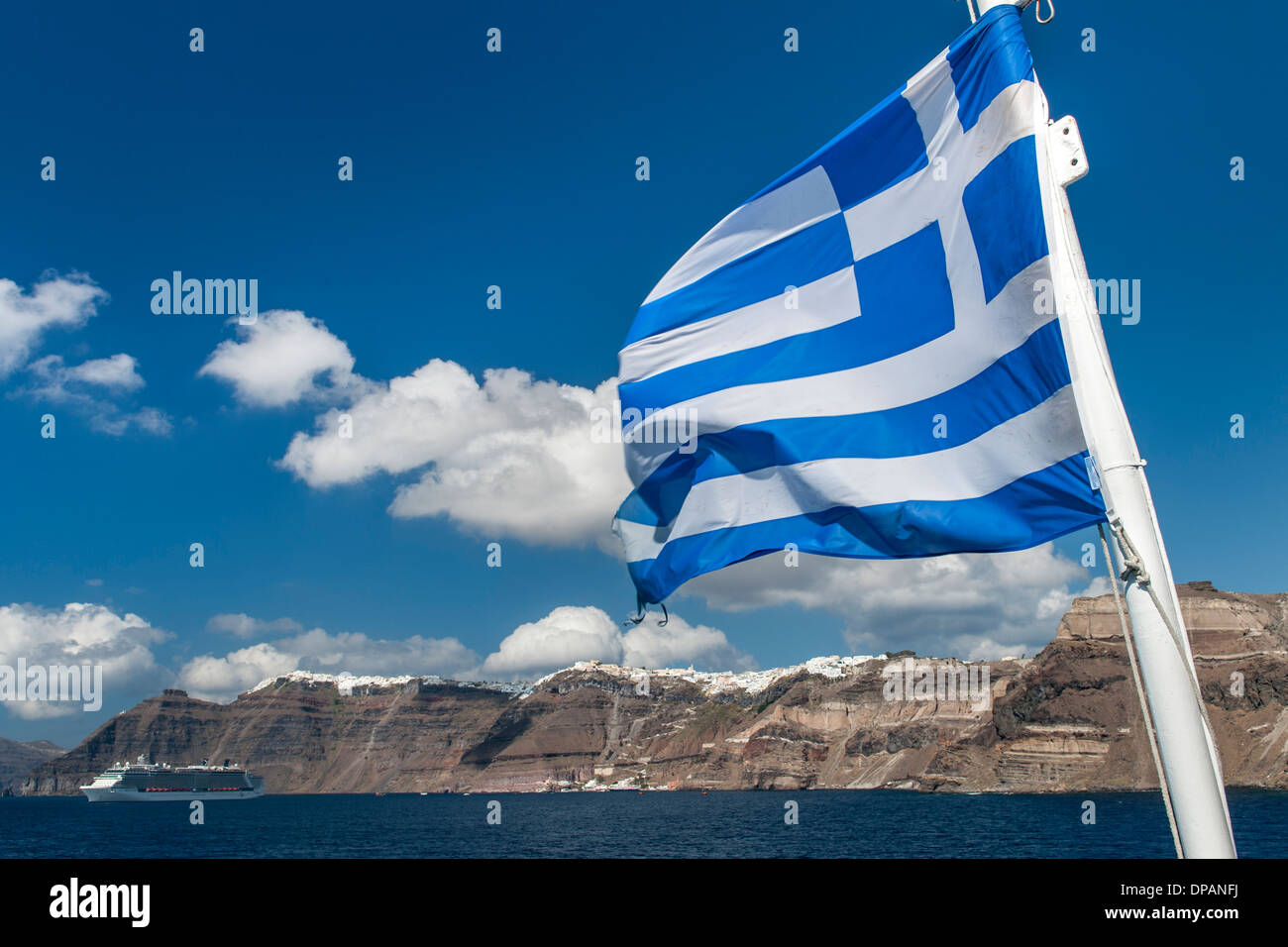 Bandiera Greca visto contro una vista dell'isola di Santorini. Foto Stock
