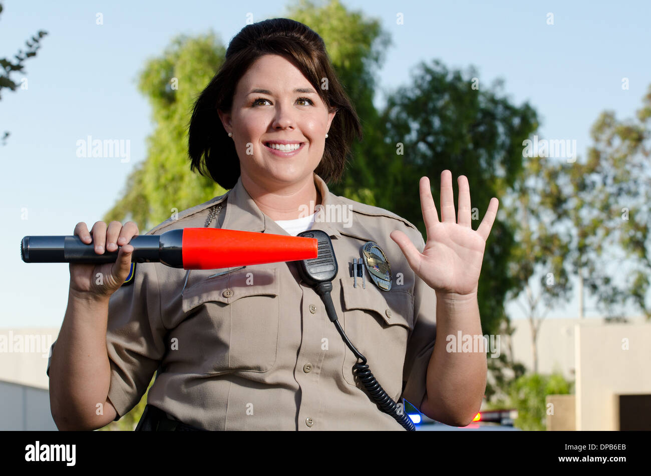Una femmina di polizia officer mantiene le sue mani fino a mostrare il traffico che lei vuole vetture per interrompere. Foto Stock