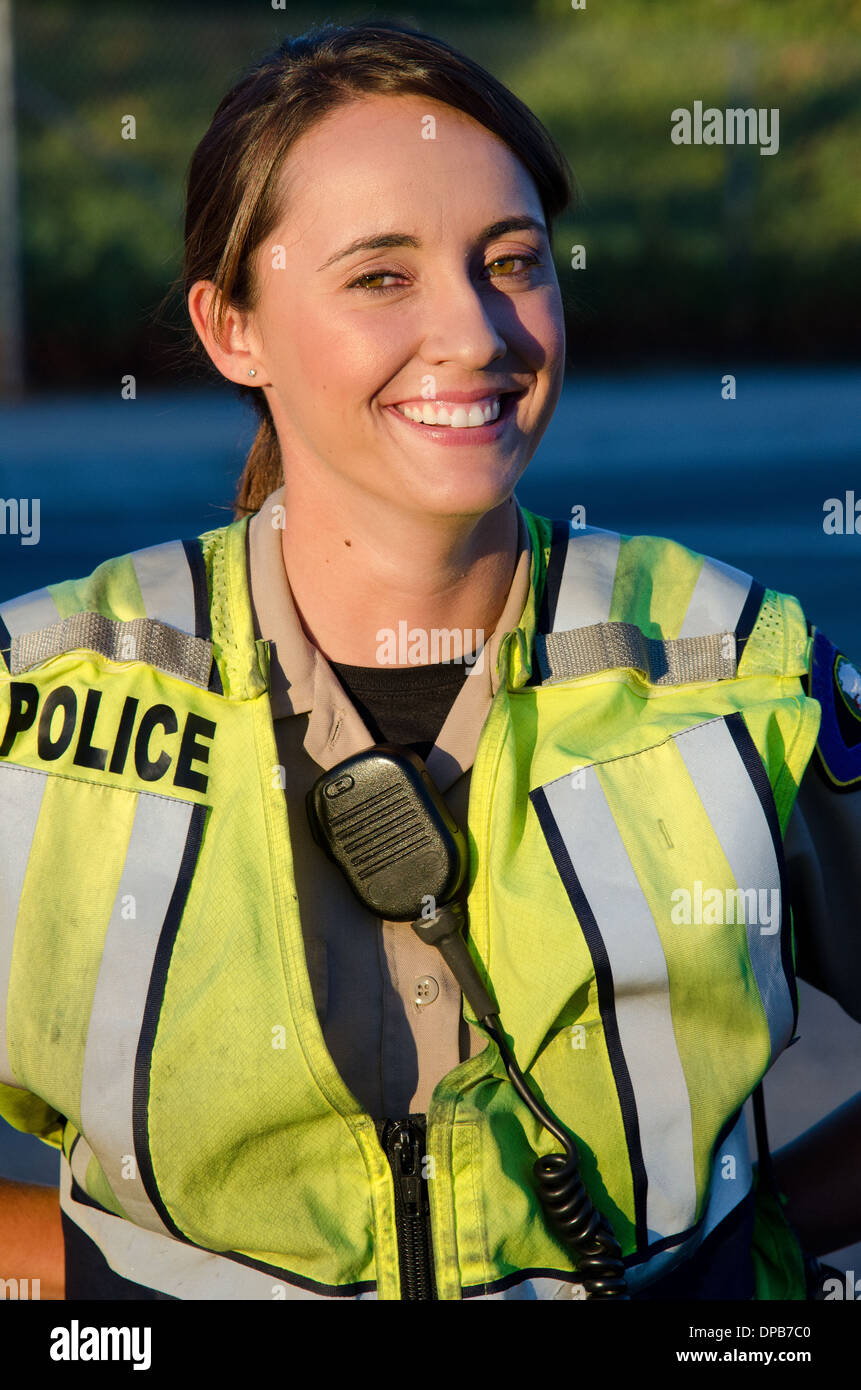 Una femmina di funzionario di polizia sorrisi durante il suo turno. Foto Stock