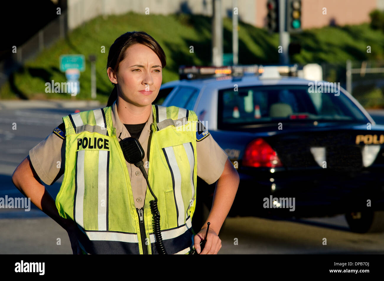 Una femmina di funzionario di polizia staring e guardando gravi durante un controllo del traffico di turno. Foto Stock