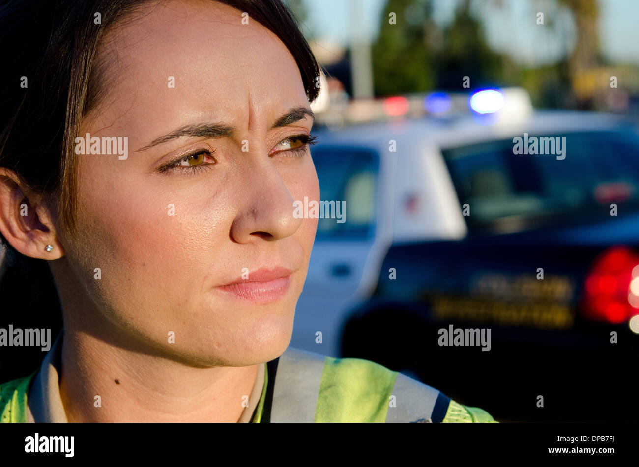 Una femmina di funzionario di polizia staring e guardando gravi durante un controllo del traffico di turno. Foto Stock