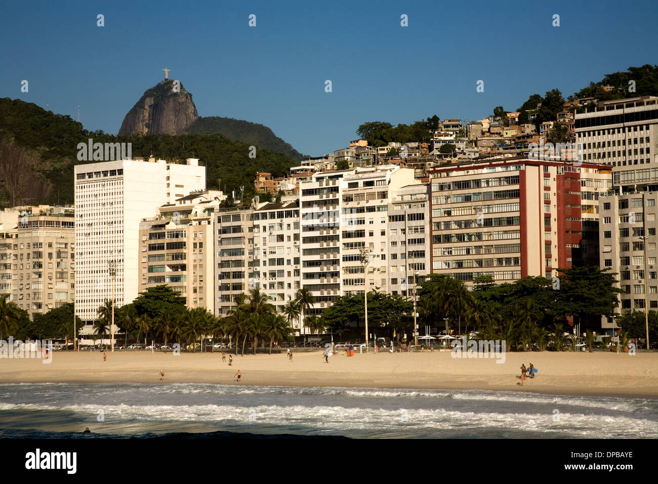 Spiaggia di Copacabana ed edifici con vista di favela e Cristo redentore (Corcovado) in background. Rio de Janeiro in Brasile. Foto Stock