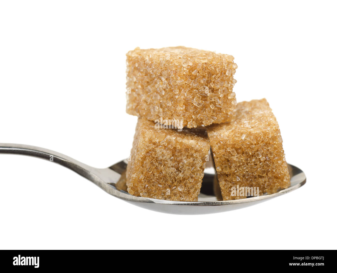 Tre di zucchero di canna i cubi su cucchiaio isolato su bianco Foto Stock