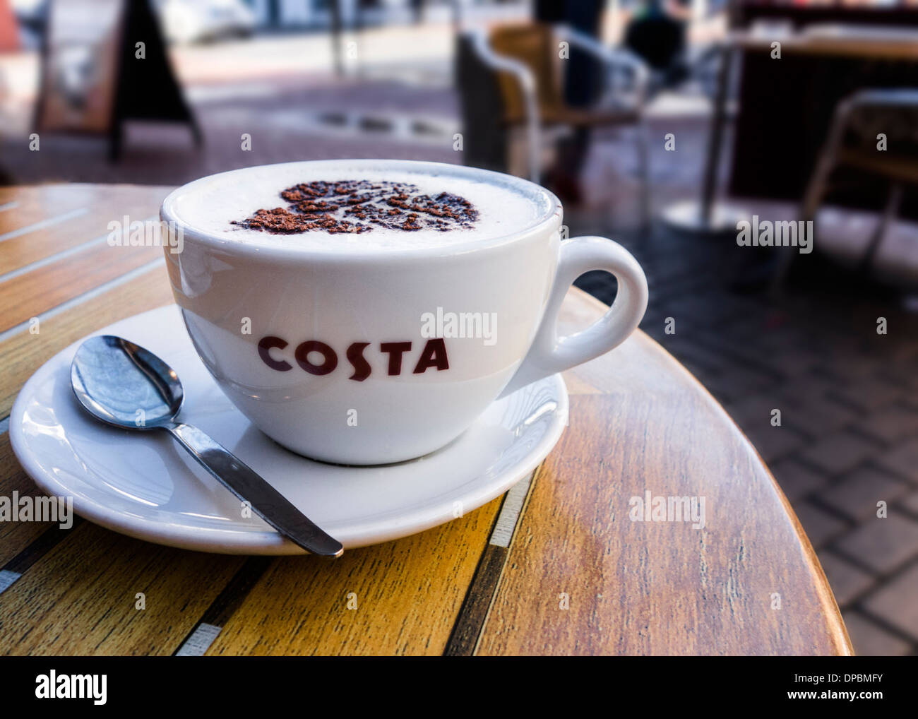 Un cappuccino in un tavolo esterno in corrispondenza di una Costa Coffee bar. Foto Stock