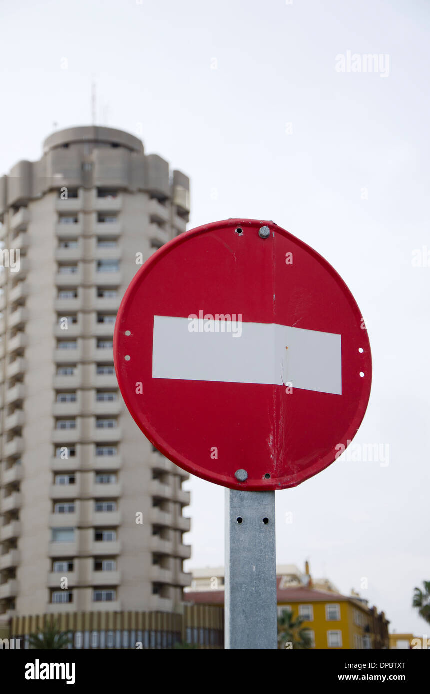 Piegare nessun segno di entrata con alto edificio in background in Fuengirola, Spagna. Foto Stock