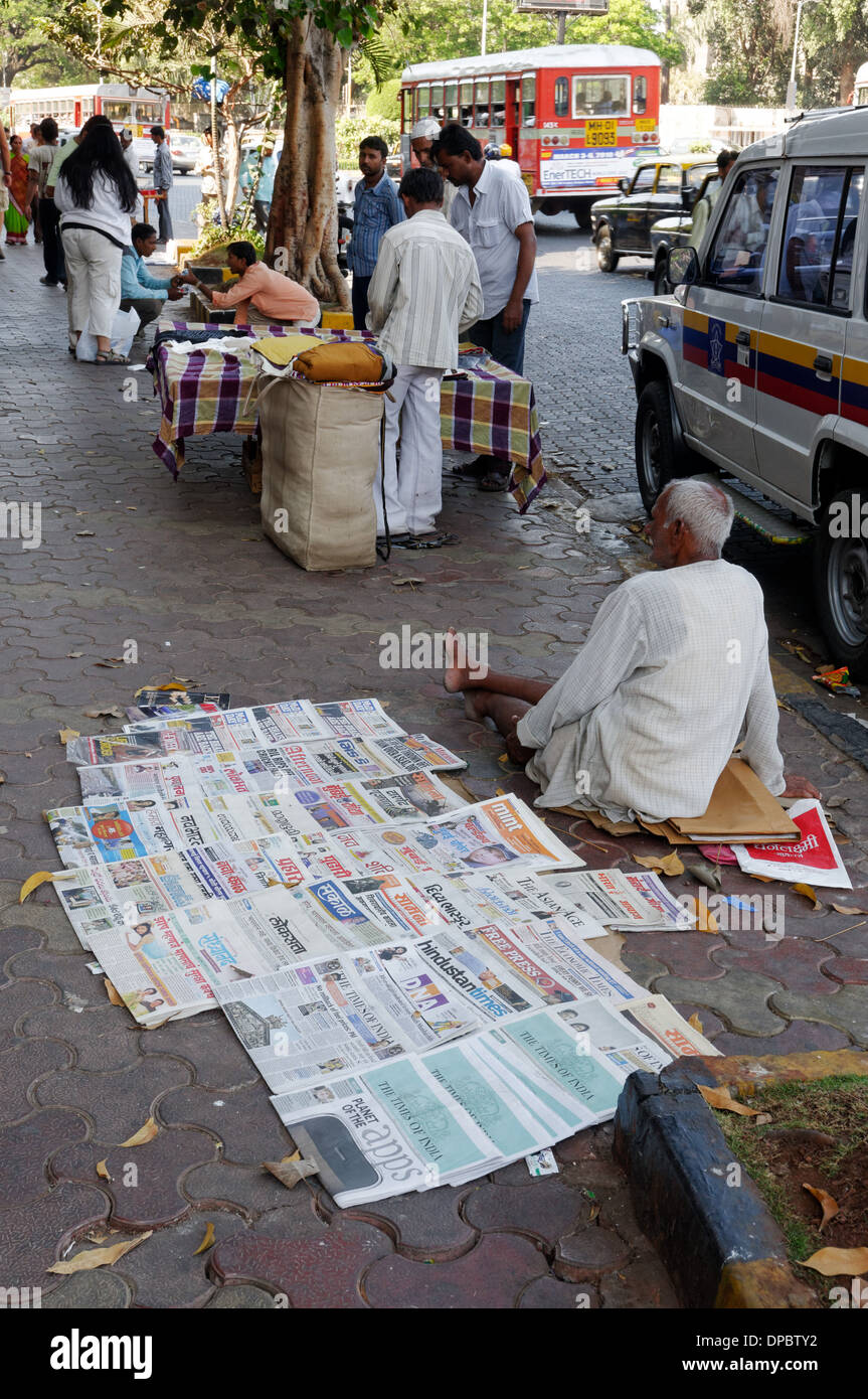 Un uomo a vendere giornali a Bombay in India Foto Stock