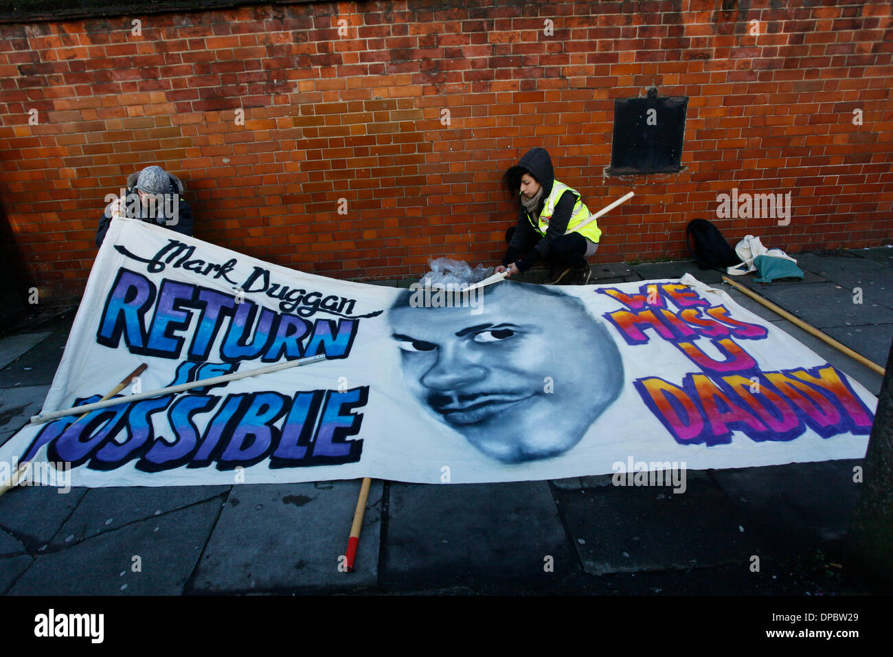 Tottenham, Londra, Regno Unito. 11 gennaio 2014. I sostenitori di preparare un banner per MArk Duggan a una veglia al di fuori della stazione di polizia Foto Stock