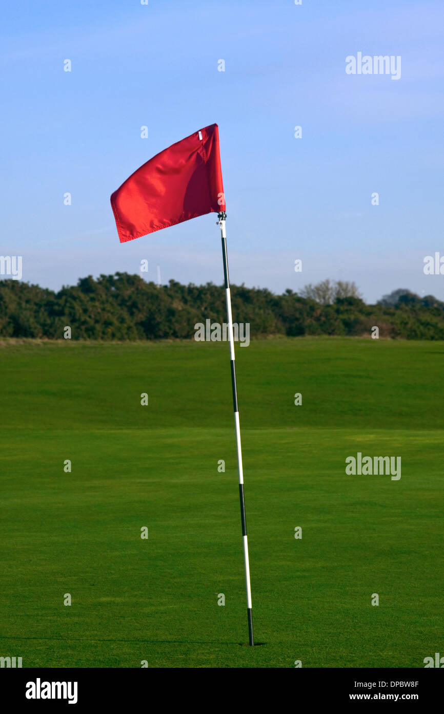 Un campo da golf rosso marcatore flag su un bianco e nero pole Foto Stock