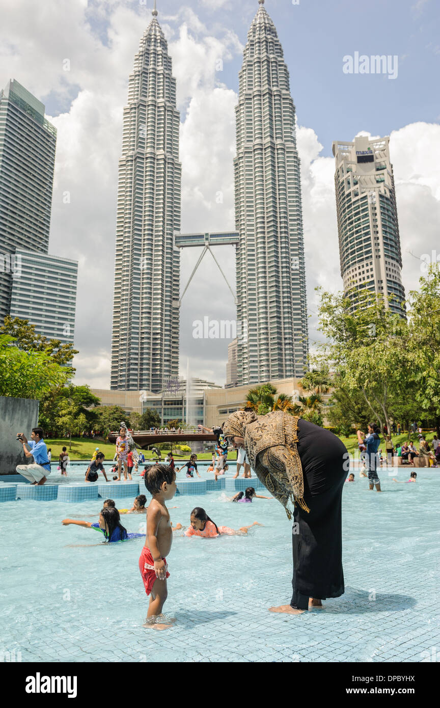Le persone che si godono le piscine nelle vicinanze torri Petronas, Kuala Lumpur, Malesia, Asia Foto Stock