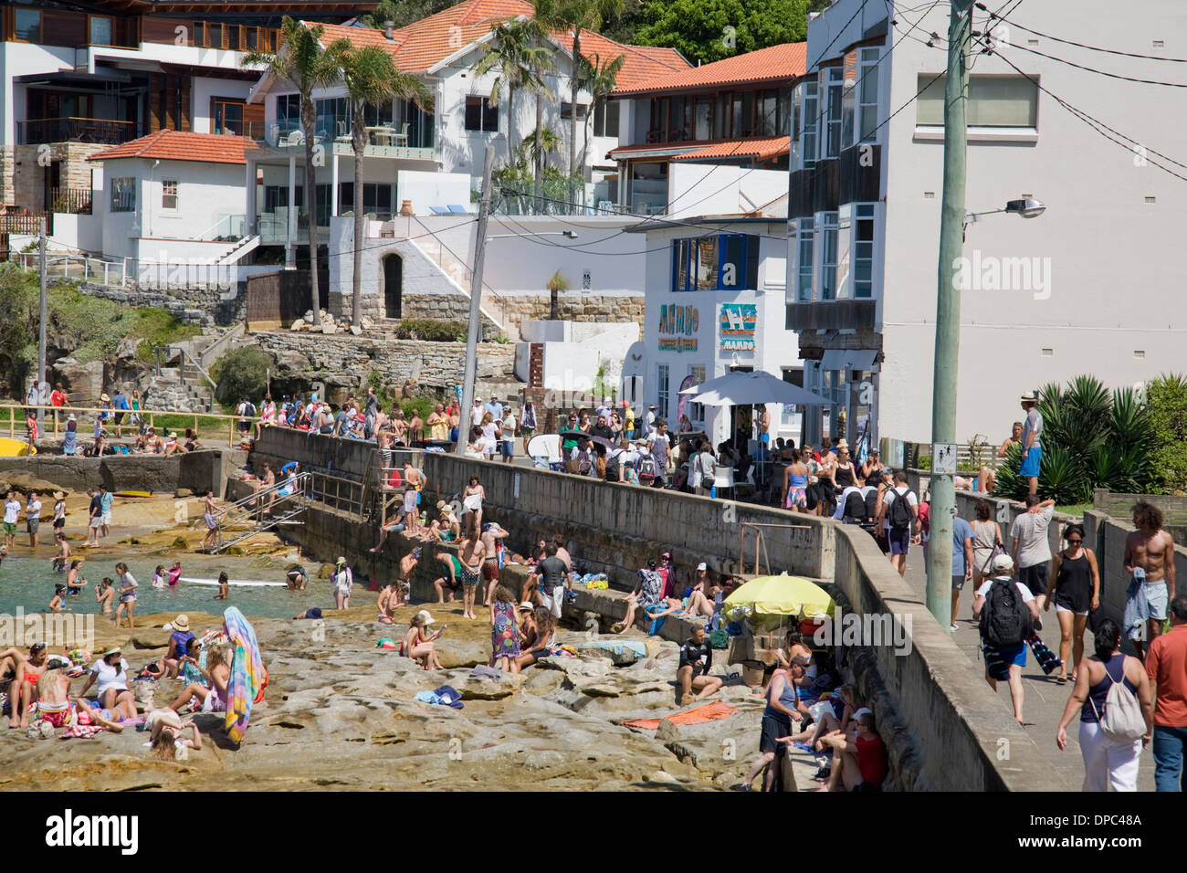 Folle di persone si prendono la passeggiata lungo la costa tra le spiagge di Manly e shelly, sydney, australia con piscina di mare fiabe boccidi Foto Stock