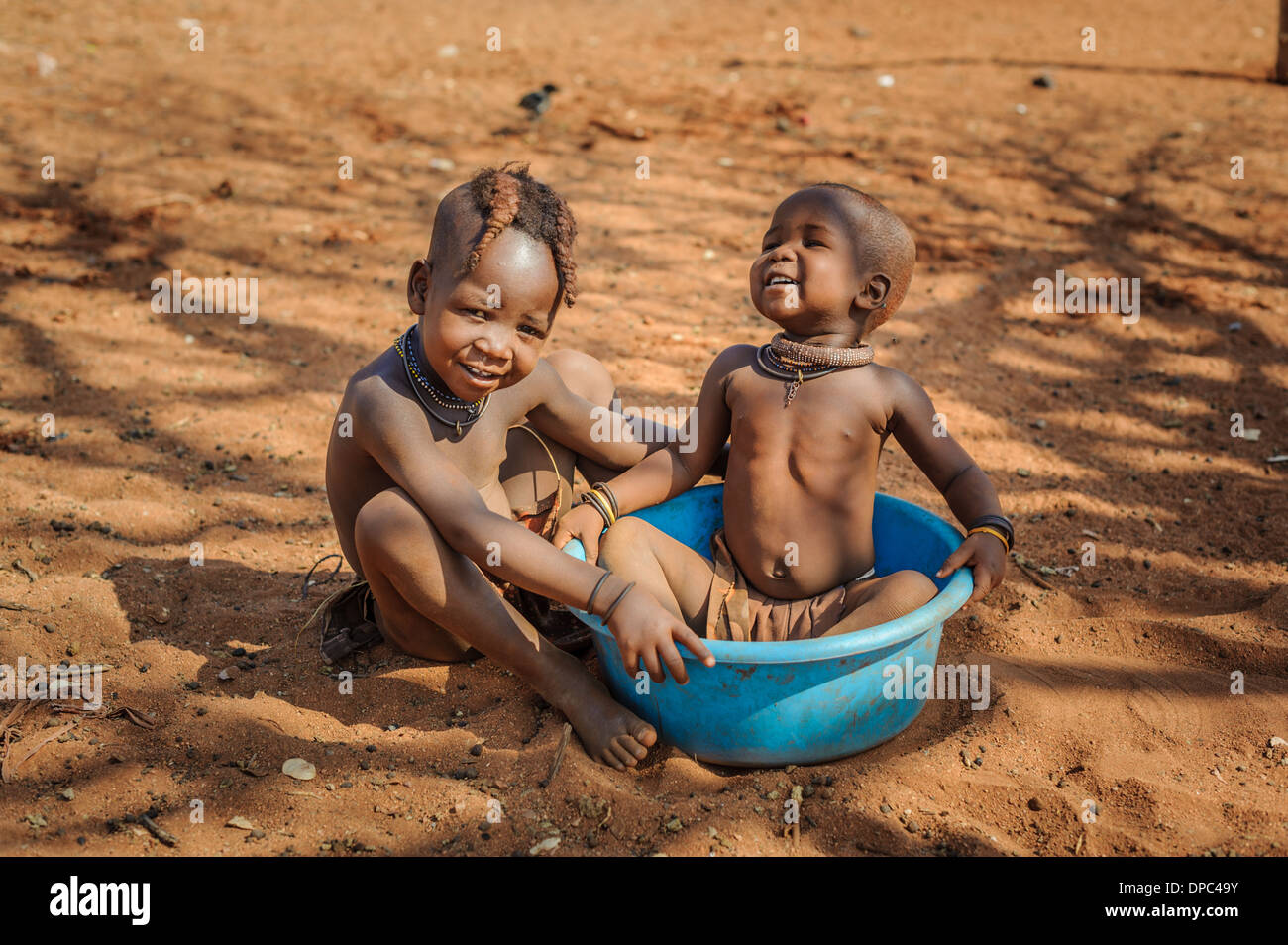 Himba bambini che giocano sul pavimento, regione di Kunene, Namibia, Africa Foto Stock