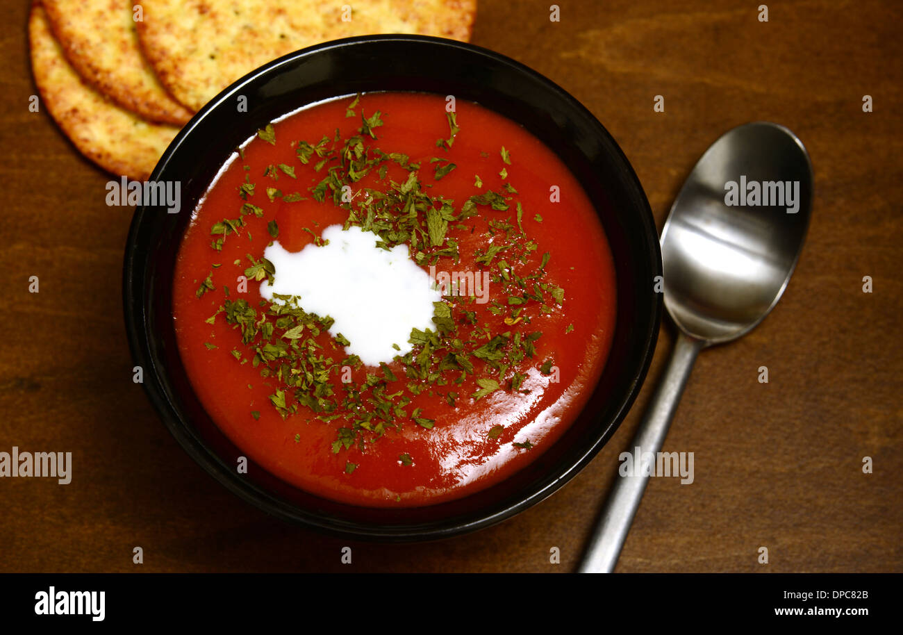 Zuppa di pomodoro e crackers su un rustico sfondo di legno Foto Stock