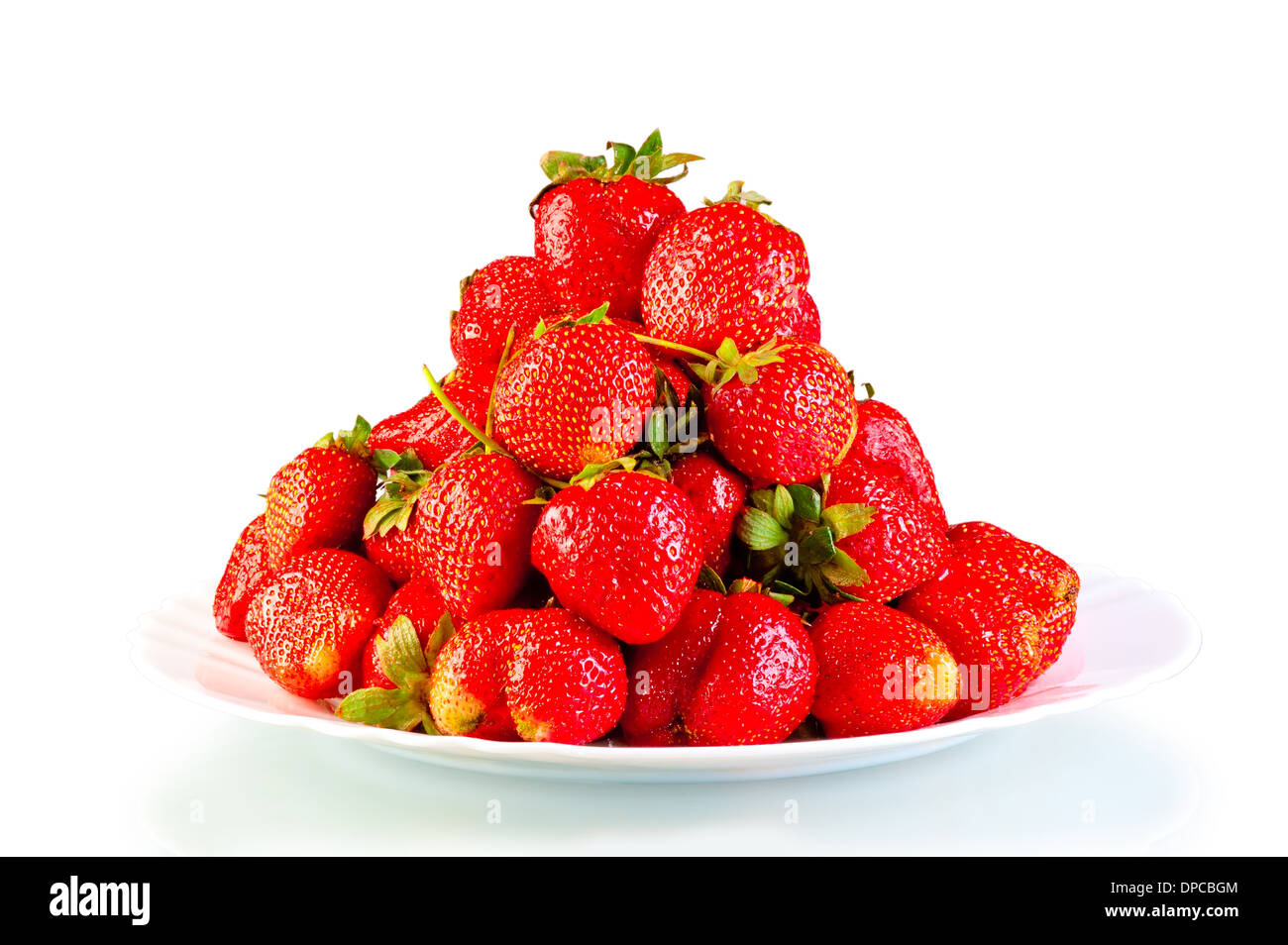 Pila di fragole di giardino su una piastra isolata Foto Stock