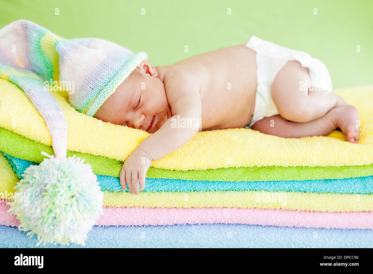 Neonato ragazza dorme sul colore asciugamani Foto Stock