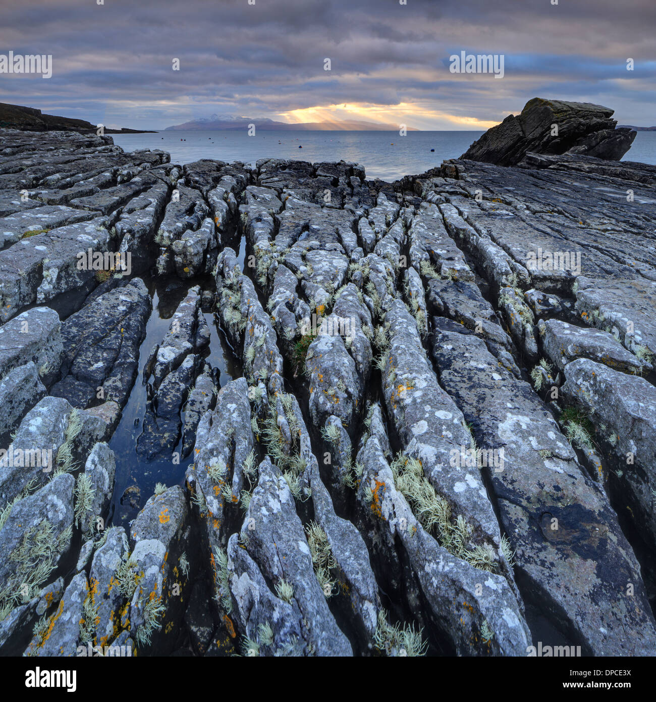 Spiaggia rocciosa di Elgol sull'Isola di Skye con raggi crepuscolari oltre al rum della distanza Foto Stock