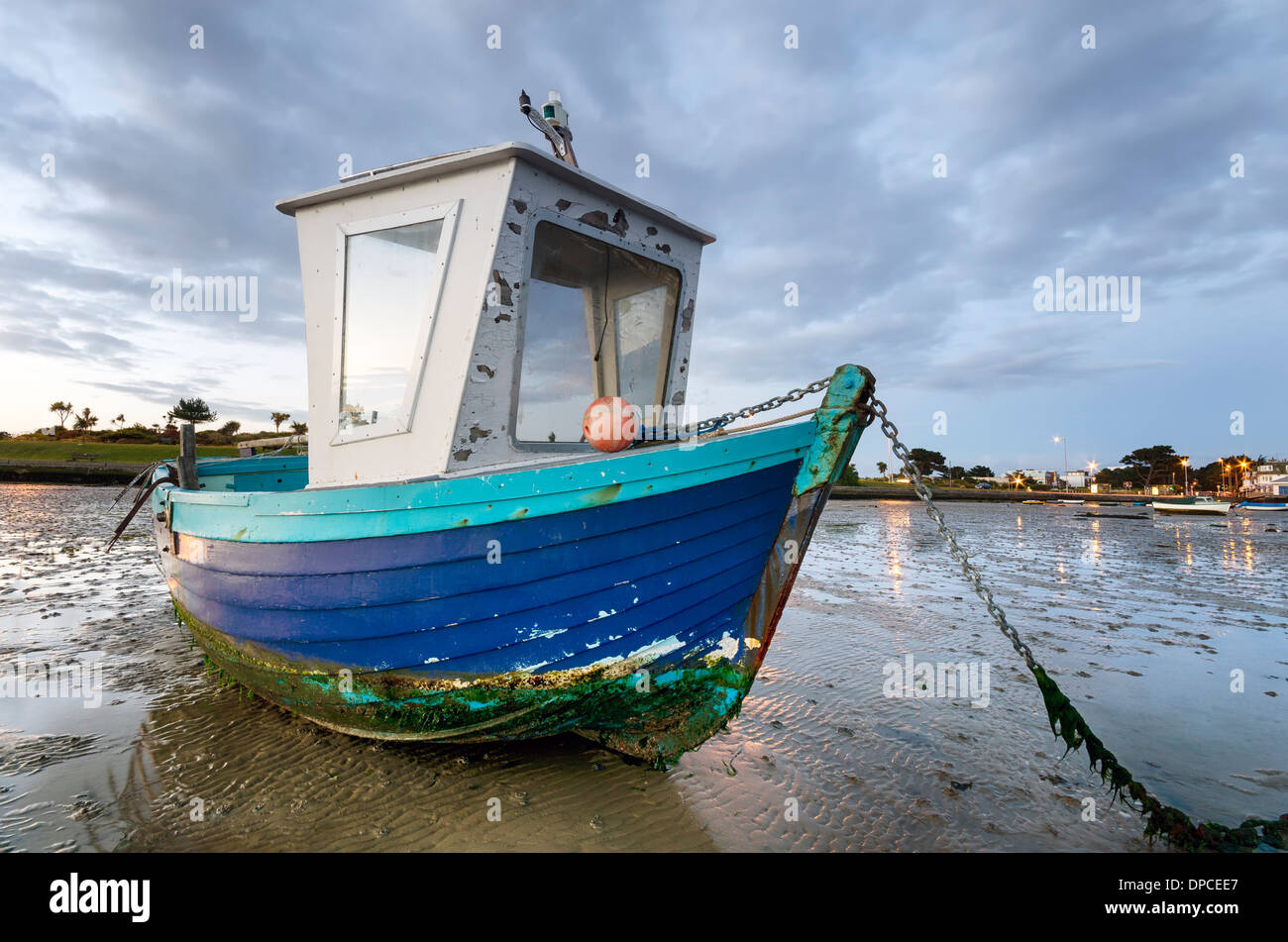 In legno di colore blu barca da pesca all'alba a banchi di sabbia spiaggia nel porto di Poole nel Dorset Foto Stock