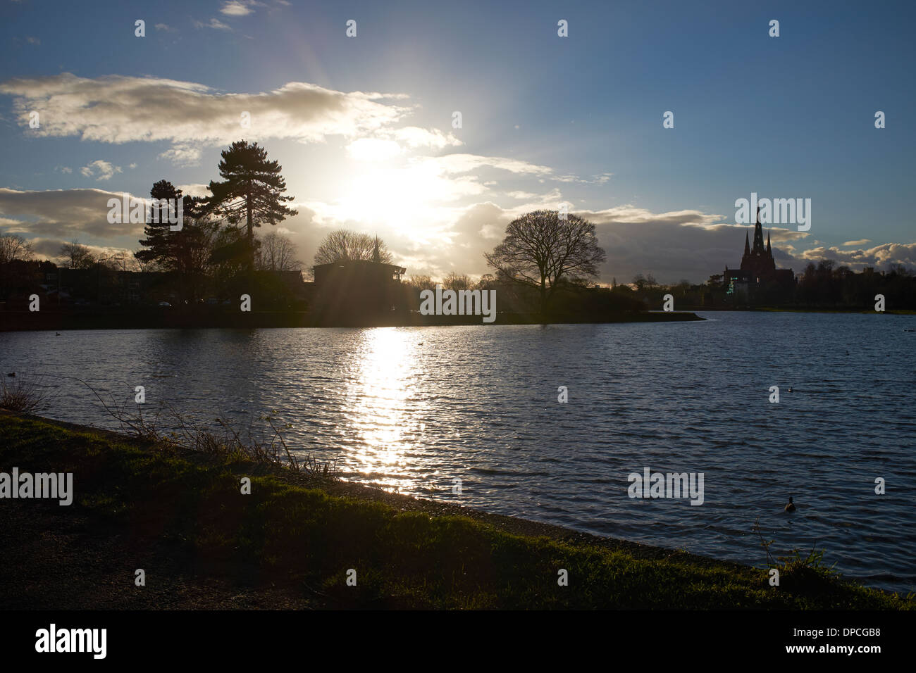 Inverno il sole tramontare sull'orizzonte di Stowe in piscina a Lichfield city centre Foto Stock