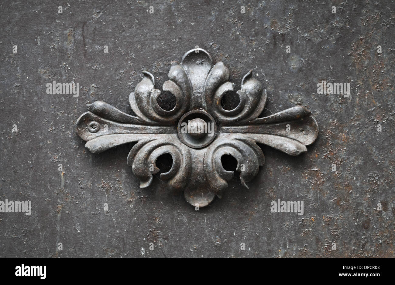 Forgiato antiche decorazioni floreali elemento su porta nera Foto Stock