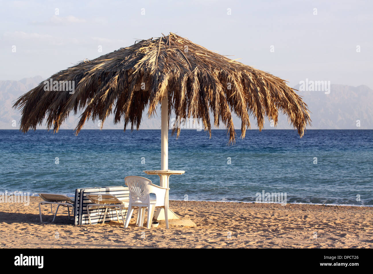 Una coperta di Palm Beach tabella affacciato sul Mar Rosso con Saudi Arabian coast attraverso l'acqua. Foto Stock