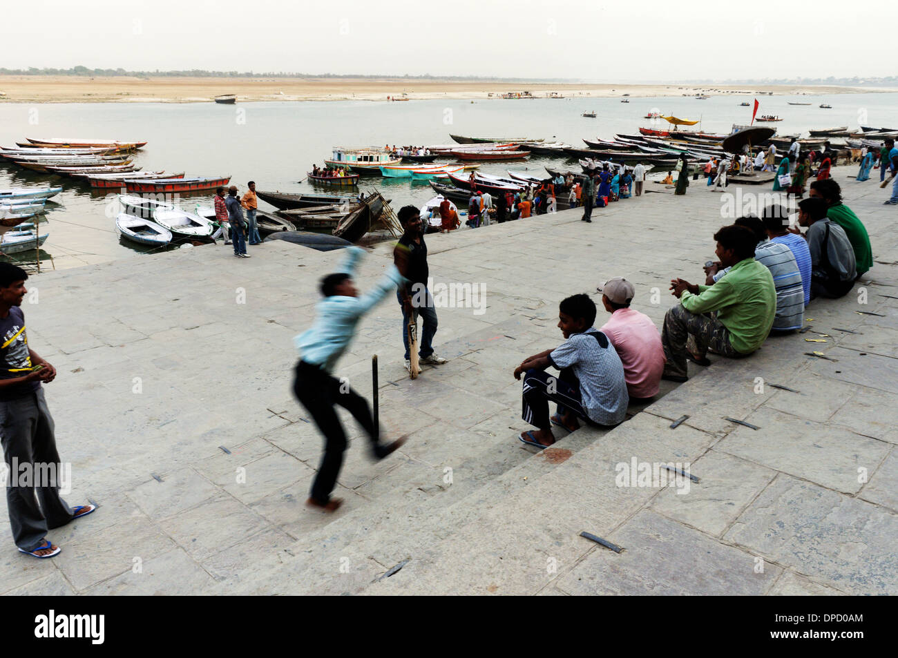 I giovani uomini a giocare a cricket sulla ghats accanto al Gange a Varanasi Foto Stock