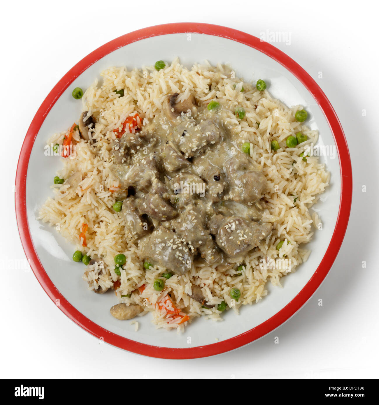 Cremosa di agnello korma curry guarnito con semi di sesamo tostati e servite su un letto di verdure, Pilaf dal di sopra Foto Stock