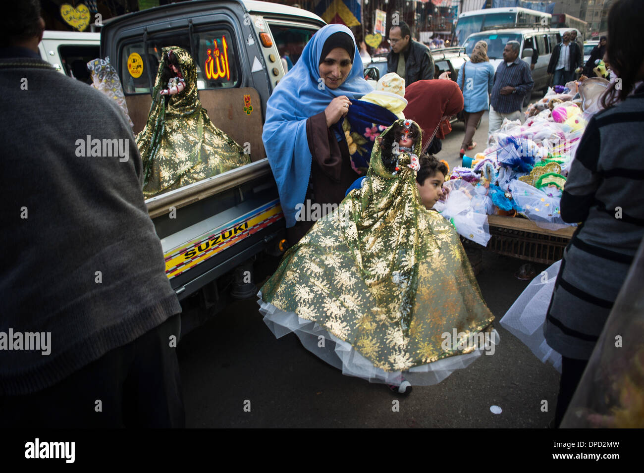 Il Cairo. Xii gen, 2014. Un ragazzo aiuta a spostare il nuovo arrivo doll su un locale mercato islamico vicino Sayyeda Zeinab moschea nella città vecchia di Cairo, capitale dell Egitto, a gennaio 12, un giorno prima del compleanno del profeta Maometto nel 2014. I musulmani in Cairo prepararsi a celebrare la festa del Lunedì da acquistare bambole e caramelle alle proprie famiglie. © Pan Chaoyue/Xinhua/Alamy Live News Foto Stock