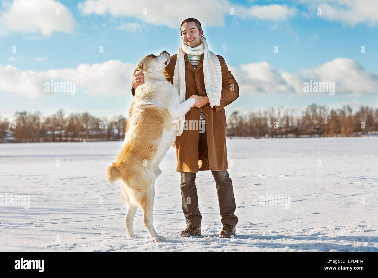 Uomo e dell Asia centrale pastore giocando con il suo cane all'aperto Foto Stock