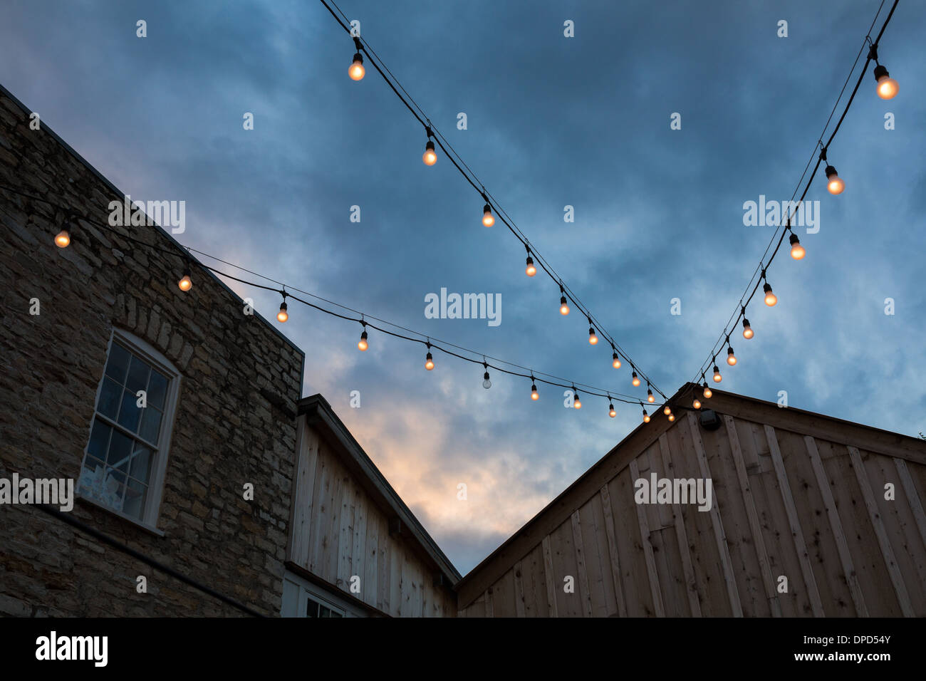 Tramonto spettacolare su un rustico stile rustico edificio con una stringa di luci Foto Stock