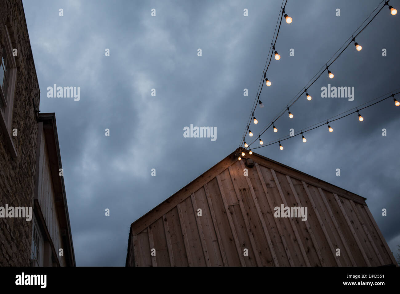 Tramonto spettacolare su un rustico stile rustico edificio con una stringa di luci Foto Stock