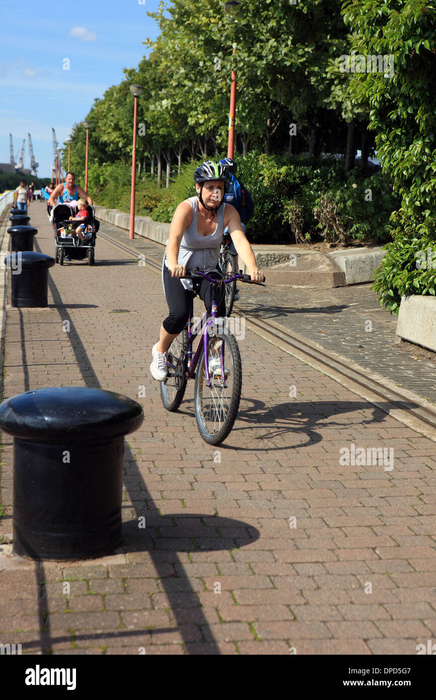 Il ciclista e il corridore spingendo una carrozzina lungo le rive del fiume Clyde a Glasgow Scozia Scotland Foto Stock