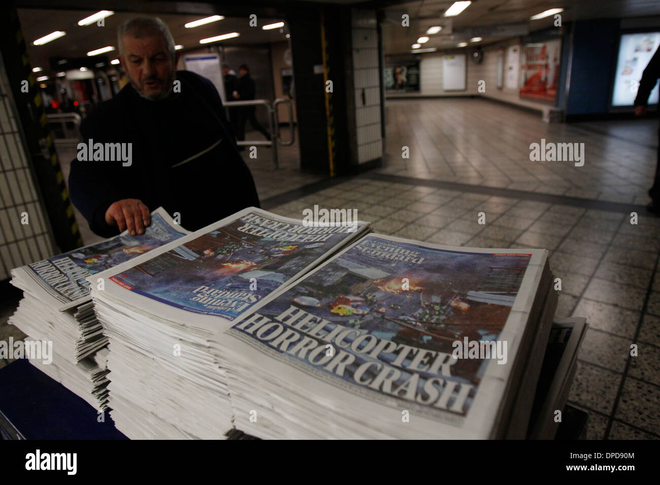 Passeggeri scegliere una copia del London Evening Standard quotidiani presso il tubo di Vauxhall Station di Londra Foto Stock