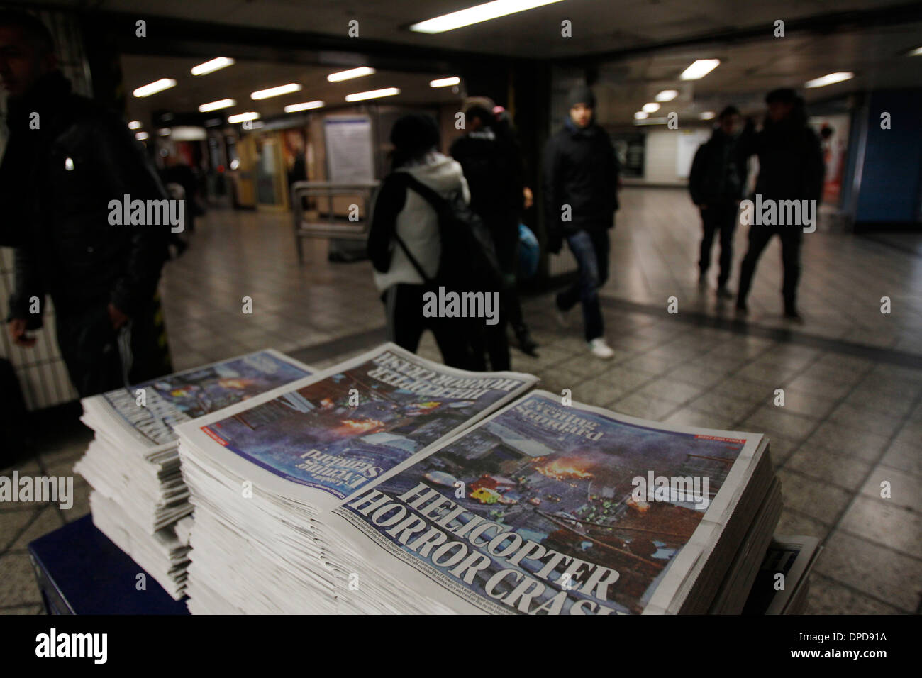 Passeggeri scegliere una copia del London Evening Standard quotidiani presso il tubo di Vauxhall Station di Londra Foto Stock