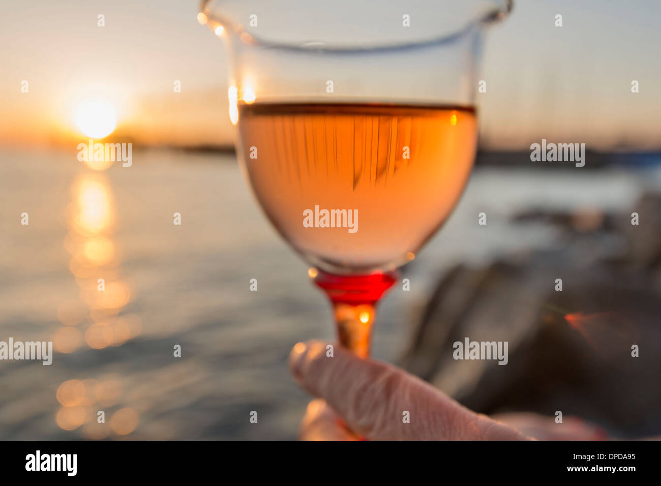 In Germania, in Baviera, Nonnenhorn, un bicchiere di vino in mano sulla banca del lago di Costanza Foto Stock