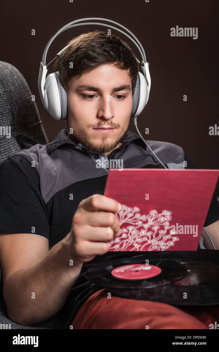Giovane uomo che indossa le cuffie ascolto di vinile Foto Stock