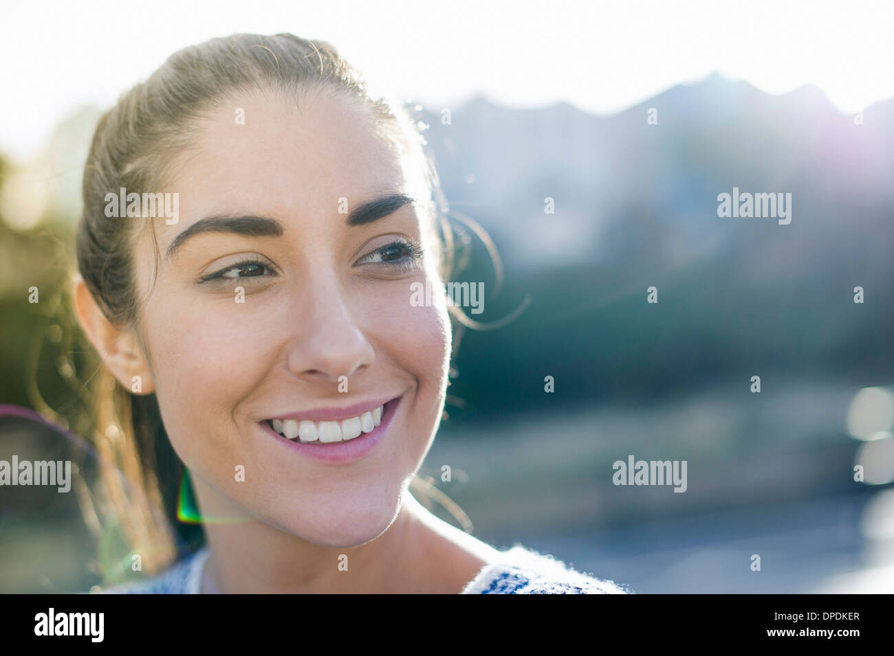 Ritratto di giovane donna che guarda lontano, sorridente Foto Stock