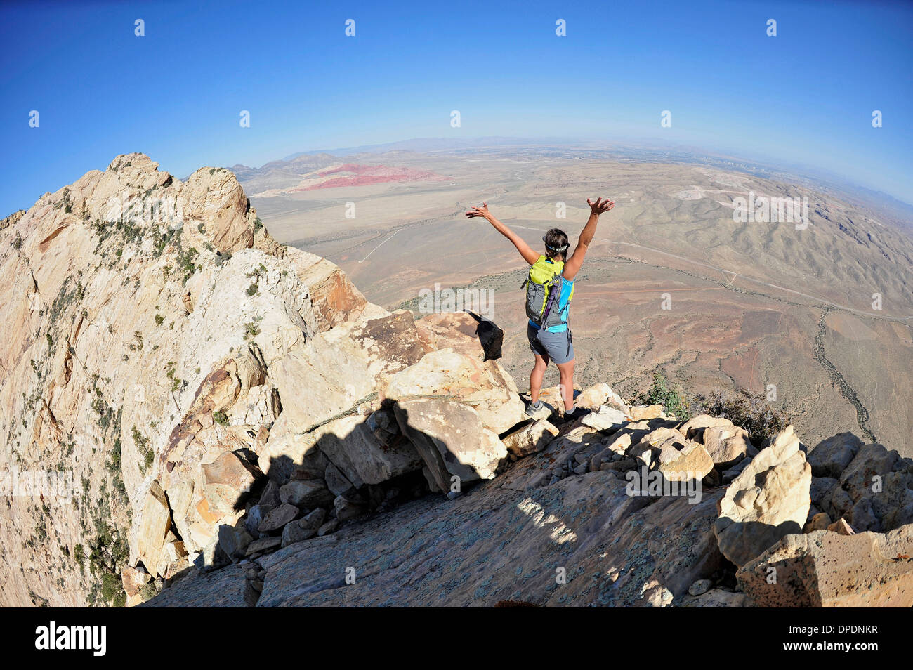 Escursionista femmina celebrando in cresta, Mount Wilson, il Red Rock Canyon, Nevada, STATI UNITI D'AMERICA Foto Stock