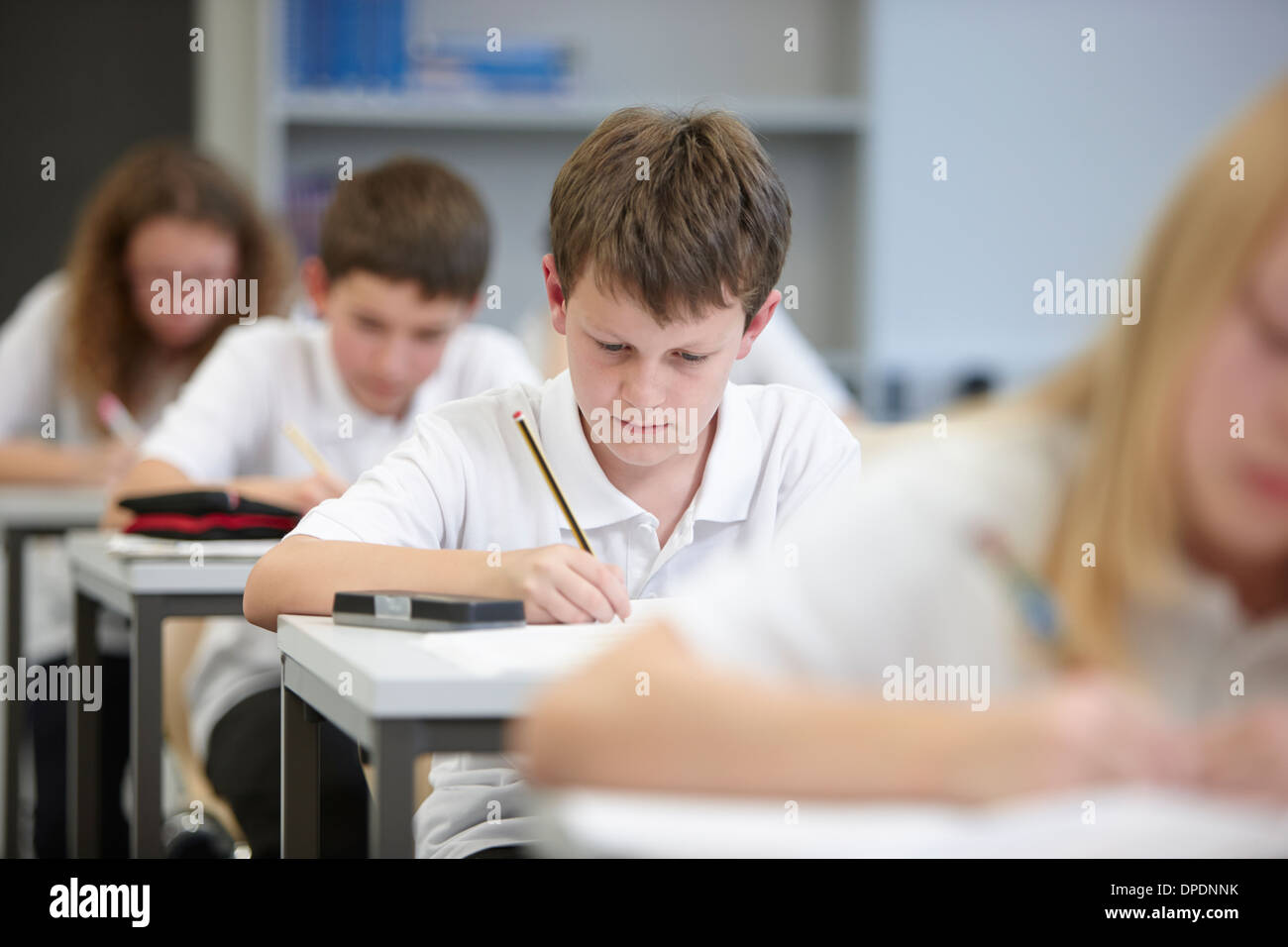 Classe di scolari facendo esame educativa Foto Stock