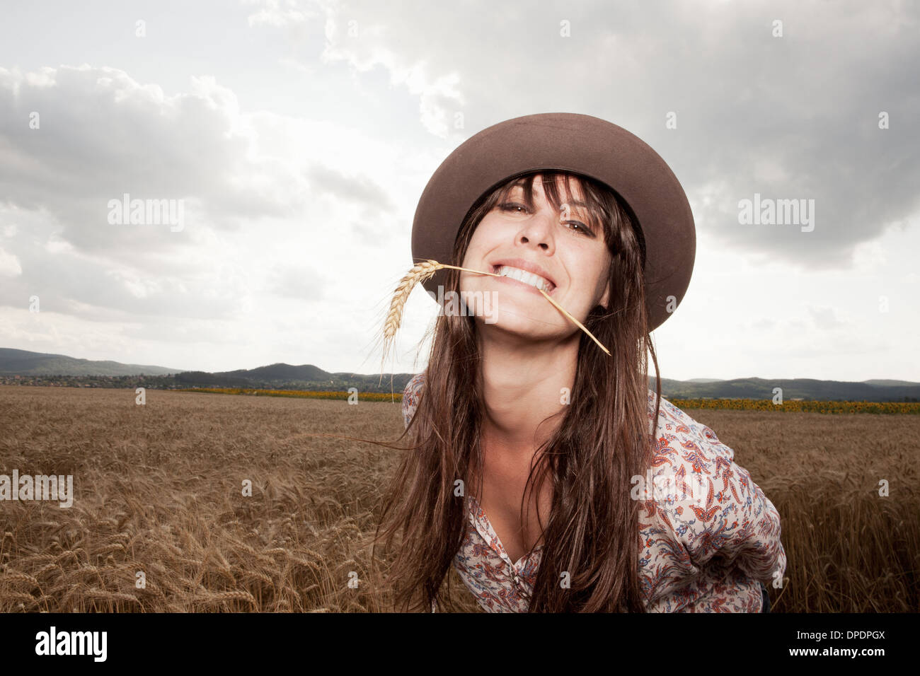 Metà donna adulta con il grano nella sua bocca Foto Stock