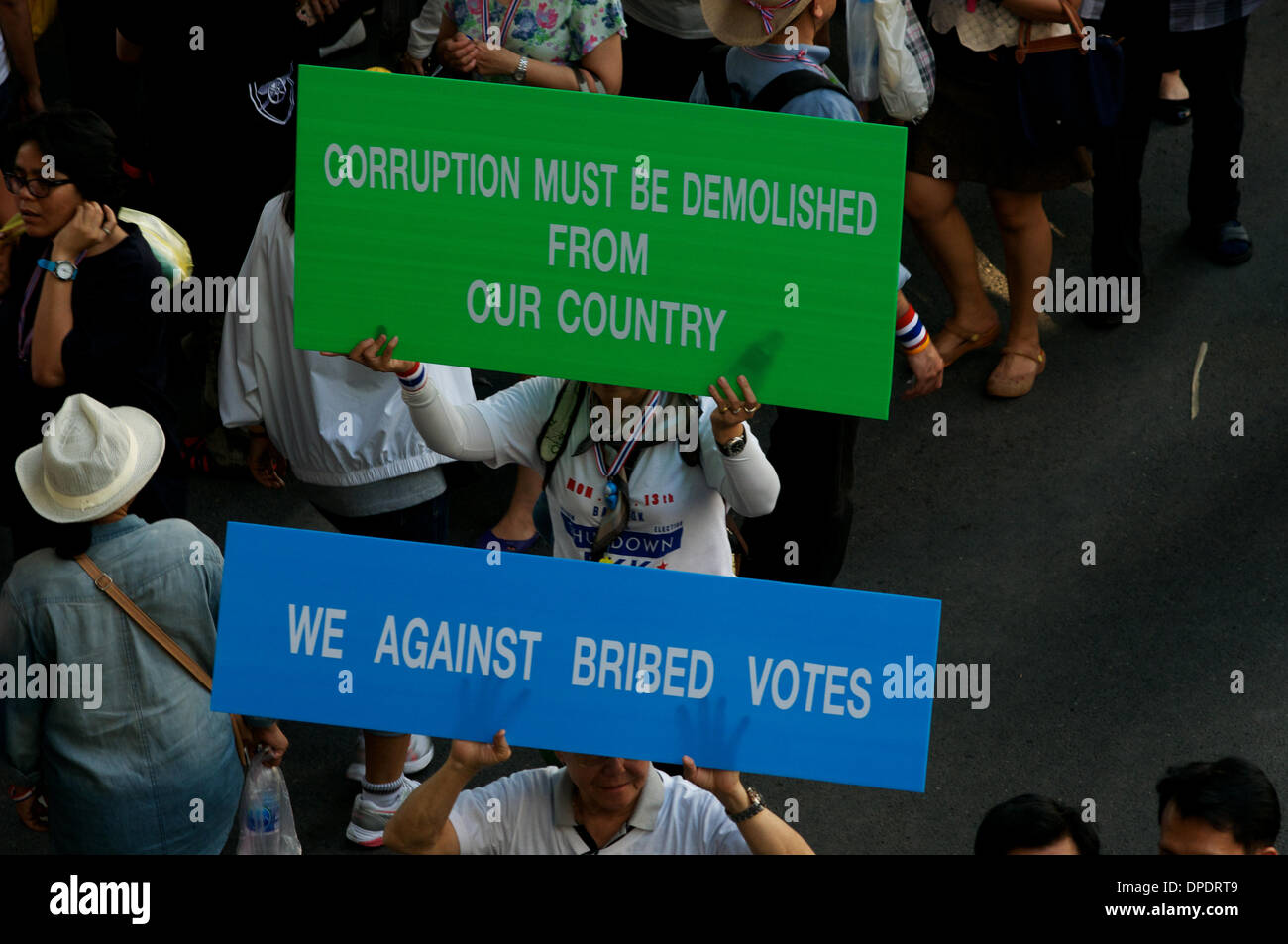 Bangkok, Tailandia. 13th gennaio 2014. I manifestanti anti del governo portano i segni e marciano lungo la strada Rama 1 nel centro di Bangkok. In un tentativo di chiusura di Bangkok, decine di migliaia di manifestanti sono scesi per le strade per chiedere le dimissioni del primo ministro tailandese Yingluck Shinawatra. Il 'Shutdown Bangkok' è organizzato dal Comitato per la riforma democratica del popolo (PDRC). Credit: Kraig Lieb / Alamy Live News Foto Stock