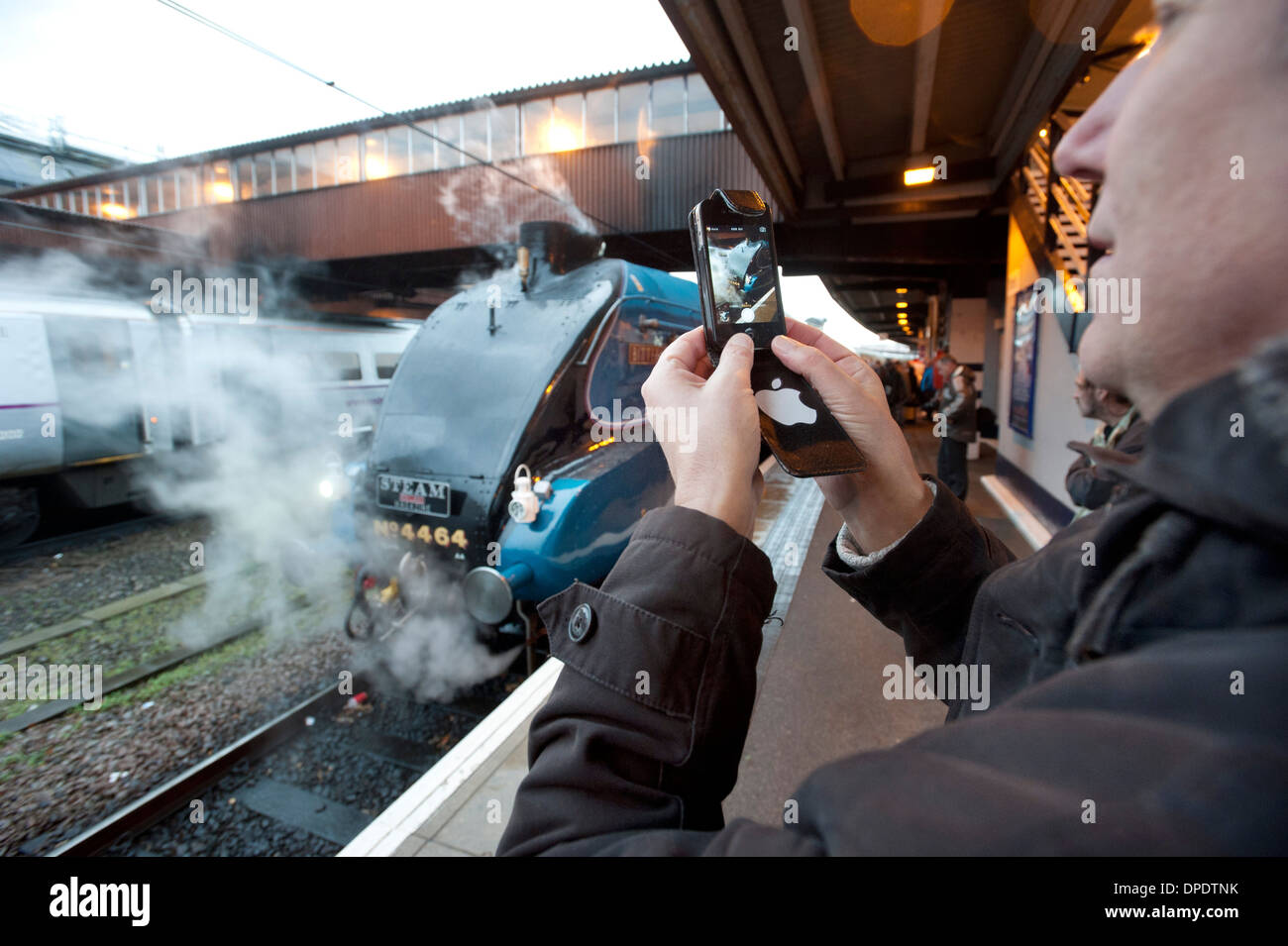 Un appassionato di Ferroviaria utilizza il suo iPhone di Apple per fotografare un London North Eastern Railway (LNER) Classe A4 locomotiva a vapore. Foto Stock