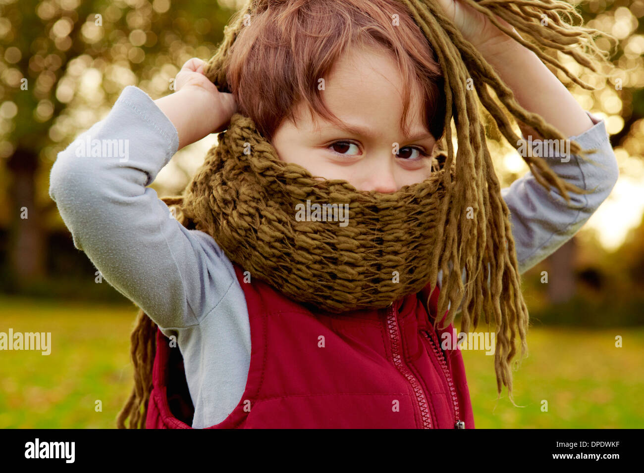 Ragazzo nel parco, con una sciarpa che copre la bocca Foto stock - Alamy