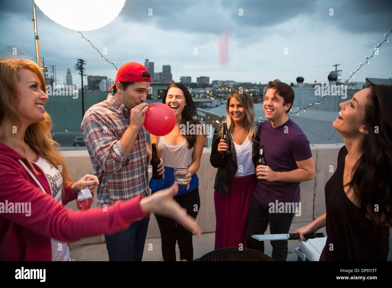 Giovani amici adulti ingannare intorno al barbecue Foto Stock